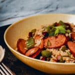 Skillet red beans and rice with smoked andouille sausage and scallion garnish